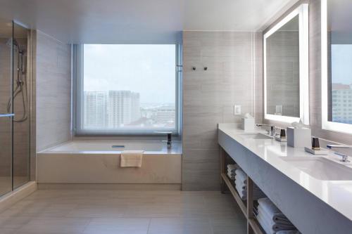 坦帕Tampa Marriott Water Street的一间带两个盥洗盆、浴缸和窗户的浴室