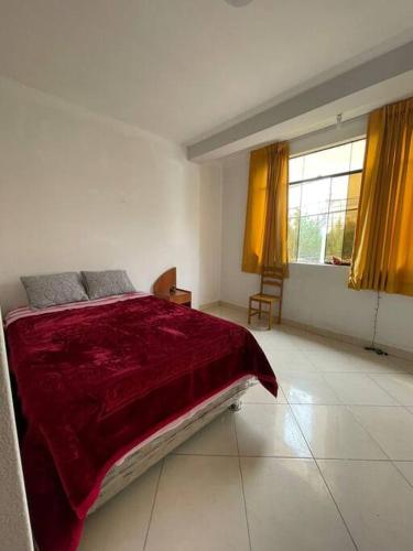HuantaYachanapaq Wasi III的一间卧室配有一张带红色毯子的大床