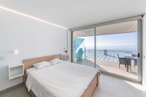 福恩吉罗拉Serene Seaview Retreat in Higueron: 2BR Oasis的一间卧室设有一张床和一个阳台