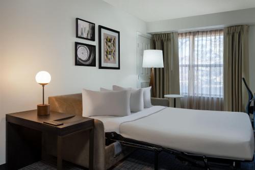路易维尔Residence Inn by Marriott Boulder Broomfield的酒店客房设有一张大床和一张沙发。