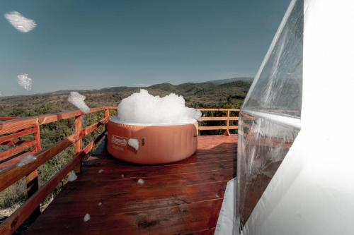 巴拉奥纳省圣克鲁斯Ovalulú Glamping Hotel的坐在房子甲板上的一壶雪