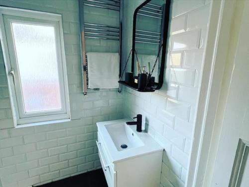 滨海绍森德Hill Grove 2 Bedroom Apartment的白色的浴室设有水槽和窗户。