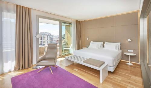 马德里马德里欧式建筑NH精选酒店的卧室设有白色的床和大窗户