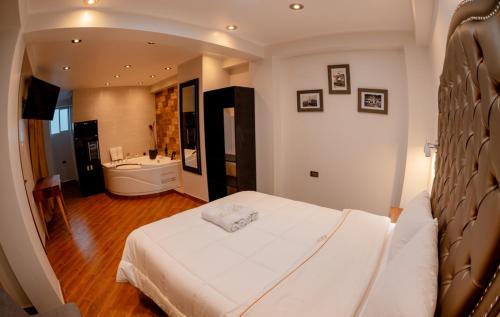 阿亚库乔Hotel Melthon Urbans的一间带白色床的卧室和一间浴室