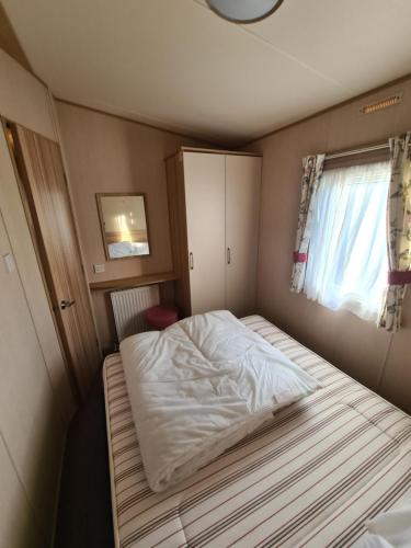 新米尔顿Hoburne Naish CS129的一个小房间的一个床位,设有窗户