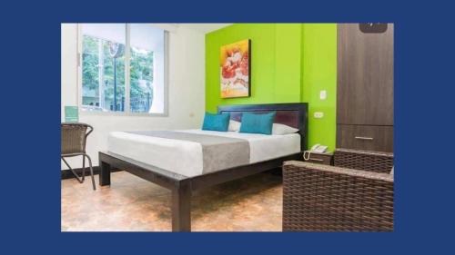 内瓦Hotel Sevilla Neiva的一间卧室设有一张床和绿色的墙壁