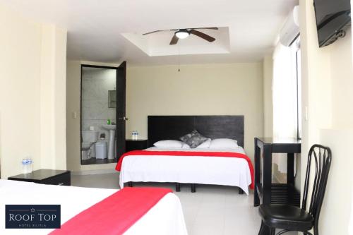 希利特拉ROOF TOP Hotel XILITLA的一间卧室配有两张床和吊扇