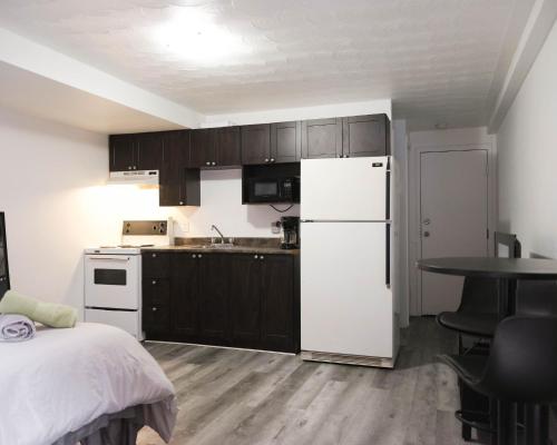 蒙特利尔Cozy studio apartment - 240的厨房配有白色冰箱和桌子