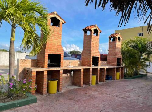 TucacasApartamento Playa Ciudad Flamingo Tucacas Chichiriviche的砖砌的建筑,上面有两个烟 ⁇ 