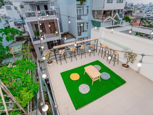 胡志明市ALOHA SAIGON HOSTEL by Local Travel Experts - Newly opened, Less-touristy location, Spacious rooms, Glass shower bathroom, Free breakfast, Quiet alley and Cultural exploration的阳台享有高空美景,配有桌椅