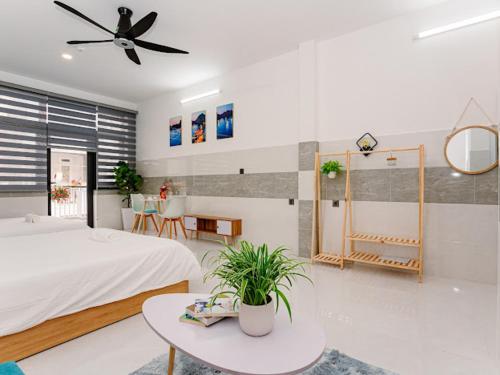 胡志明市ALOHA SAIGON HOSTEL by Local Travel Experts - Newly opened, Less-touristy location, Spacious rooms, Glass shower bathroom, Free breakfast, Quiet alley and Cultural exploration的一间卧室配有一张床、一张桌子和吊扇