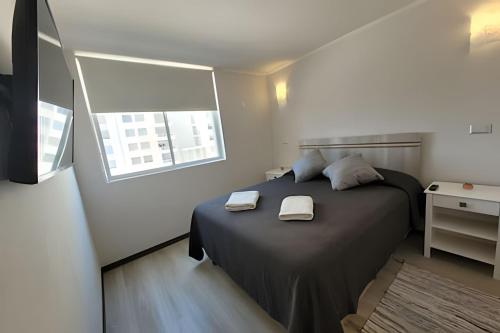 拉塞雷纳Condominio Pacífico 3100的一间卧室配有一张床,上面有两条毛巾