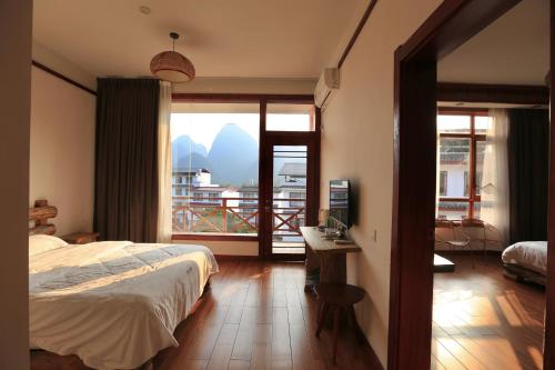阳朔阳朔小龙河酒店的一间卧室设有一张床,享有阳台的景色