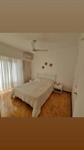 罗萨里奥Céntrico , Ideal para familias y amigos !的卧室配有白色的床,铺有木地板