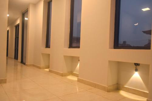 巴拉特布尔Hotel Gulmohar的一条带窗户和瓷砖地板的空走廊