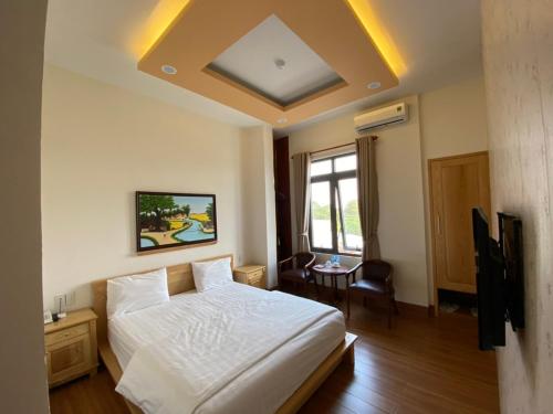 边和Hotel Như ý Biên Hòa的卧室配有白色的床和桌子