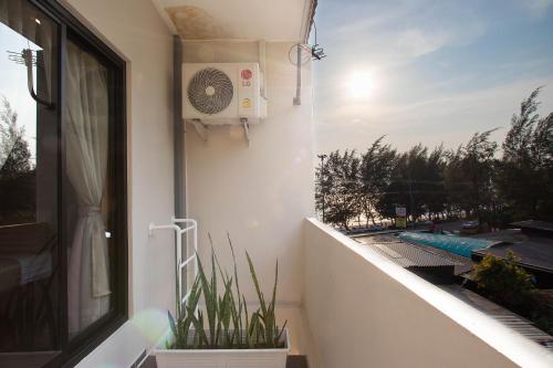 梅尔皮姆Gate78 Hostel Maephim Beach的阳台配有风扇和植物,窗户