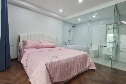 河内Penthouse Cao Cấp Tại Hà Nội的一间卧室配有粉红色的床和淋浴