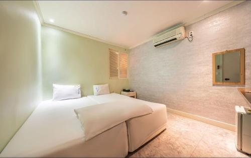 首尔Sinchon Gaon Hostel的卧室配有白色的床