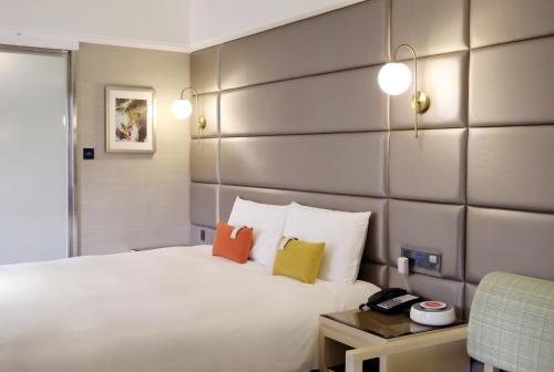 台中市悦乐旅馆 - 台中文心的卧室配有白色的床和色彩缤纷的枕头