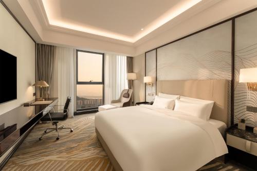杭州杭州滨江开元名都大酒店的卧室配有一张白色大床和一张书桌