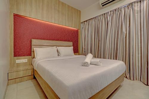 KālundriJAI MALHAR RESIDENCY的一间卧室配有一张大床和红色床头板