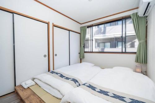 东京匯家風花ビル的一间卧室设有两张床和窗户。