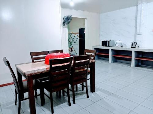 山打根ILHAM HOMESTAY Taman Sejati Mile 7的一间带桌椅的用餐室和一间厨房