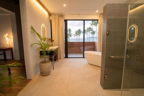爱妮岛Nacpan Beach Resort的带淋浴、浴缸和卫生间的浴室