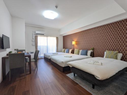 大阪ESLEAD HOTEL Namba Ebisu West的酒店客房配有两张床和一张书桌