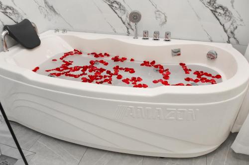 河内Chemi Noi Bai Airport Hotel的浴室内装满红色鲜花的浴缸