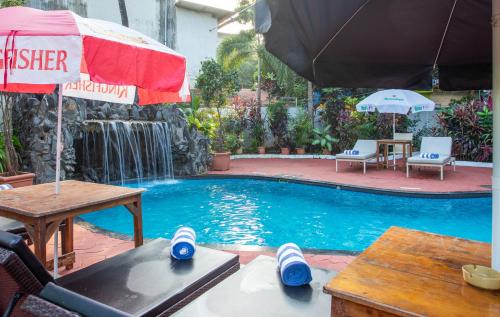 坎多林Silver Sands Sunshine - Angaara的一个带桌子和遮阳伞的游泳池