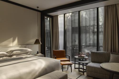 悉尼Capella Sydney的酒店客房设有一张床和一个大窗户