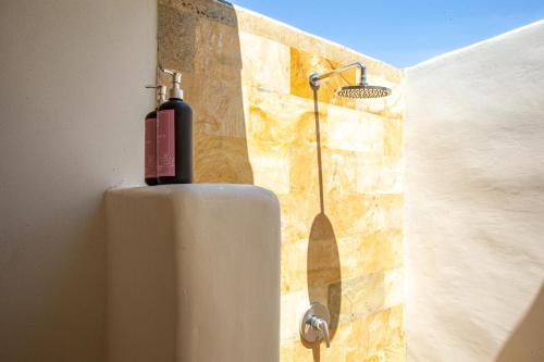 珀尼达岛La Roja Bungalows的墙上有水箱的浴室里的一个淋浴