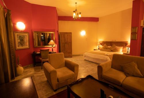 阿克拉La Palm Royal Beach Hotel的一间卧室配有一张床、一张沙发和椅子