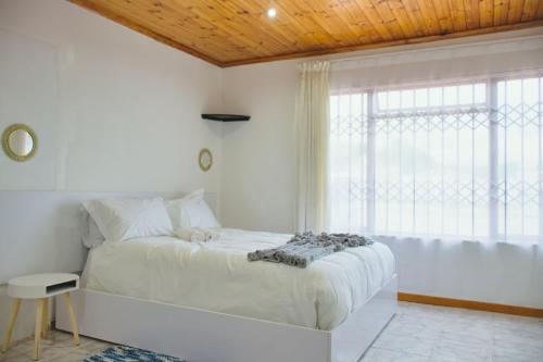 科克斯塔德Lake Acres Guest House的白色的卧室设有一张大床和一个窗户