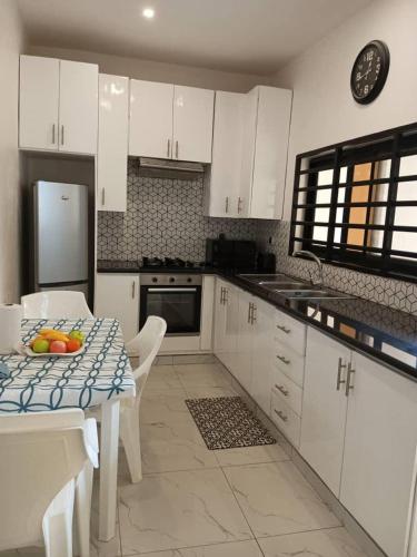 Abomey-CalaviVilla luxueuse的厨房配有白色橱柜和水果桌