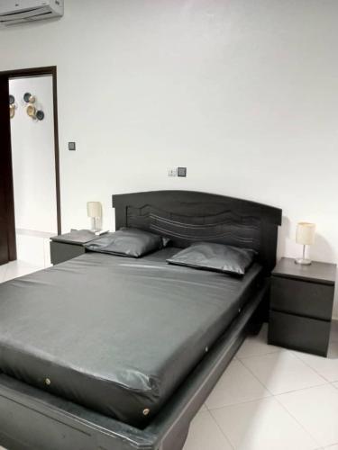 Abomey-CalaviVilla luxueuse的一张大床,位于带2个床头柜的房间