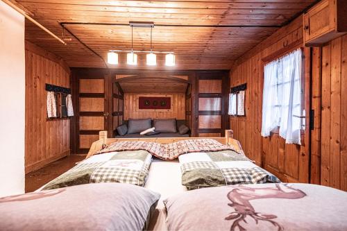 韦尔芬Almfrieden的一间带三张床的卧室,位于带木墙的房间
