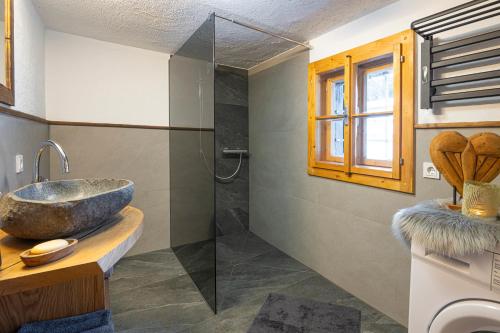 韦尔芬Almfrieden的一间带水槽和玻璃淋浴的浴室