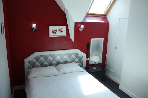 图阿尔Contact Hôtel du Relais Thouars的卧室配有白色的床铺和红色的墙壁