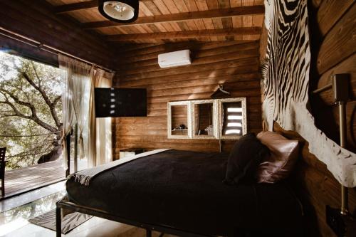 瓜达鲁佩镇Boskenvid Hotel Boutique, Skypool的小木屋内一间卧室,配有一张床