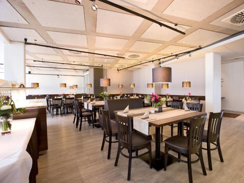 格尔林根斯图加特-格尔林根卓悦坦根斯酒店的大型用餐室配有桌椅