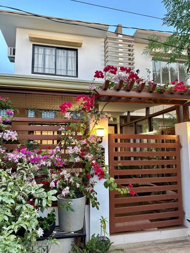 公主港Casa Privado- 2 Bedroom House Near the Airport的木栅栏上放着盆花的房子