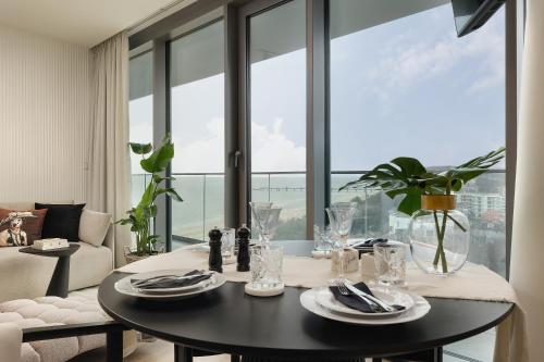 米兹多洛杰WAVE 10th Floor Baltic View的一间带桌子和大窗户的用餐室