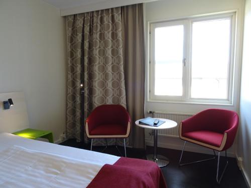 恩厄尔霍尔姆Hotell Erikslund的酒店客房带两把椅子、一张床和窗户