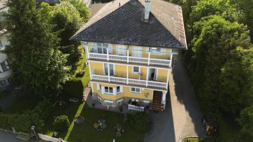 沃尔特湖畔韦尔登格特鲁德酒店的享有黄色房屋的顶部景色,屋顶为黑色