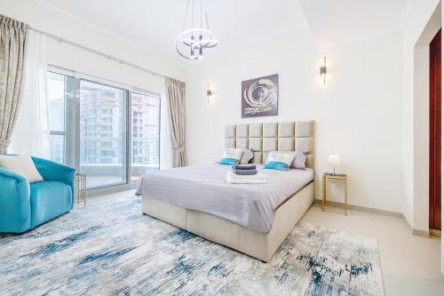 迪拜Elegant 3BR in JBR w/ partial Marina View的一间卧室配有一张大床和一张蓝色椅子