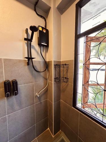 南芭堤雅Hostel Friends Station & Cafe的墙上设有带吹风机和淋浴的浴室