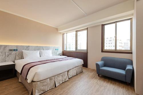 台中市沫秋立柳川行旅的一间卧室配有一张大床和一张蓝色椅子